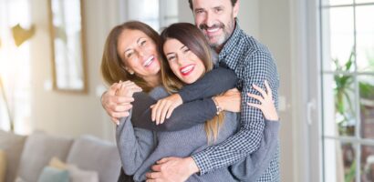Beautiful family together. Mother, father and daughter smiling and hugging with love at home.